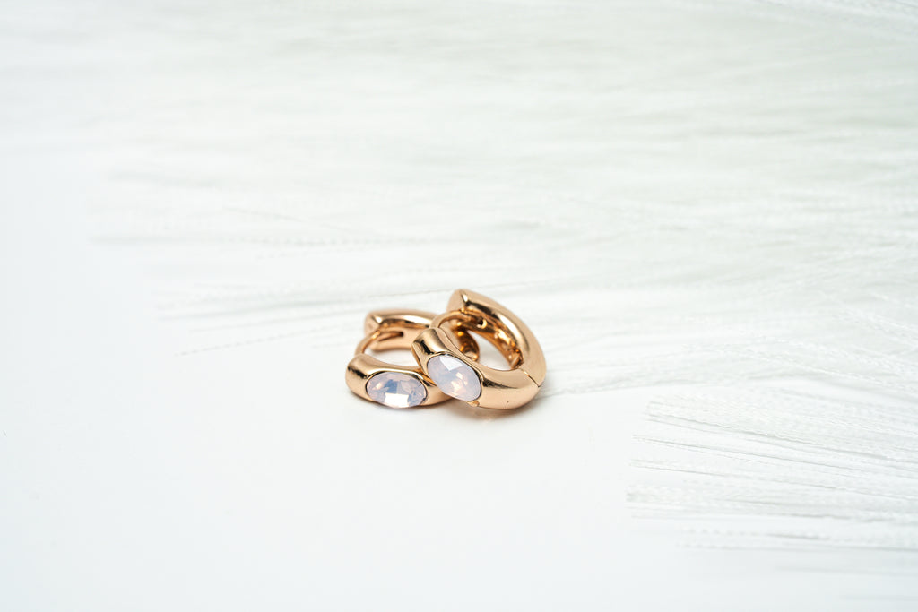 Gold ring with two circular stones on a light background