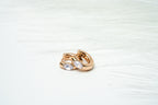 Gold ring with two circular stones on a light background