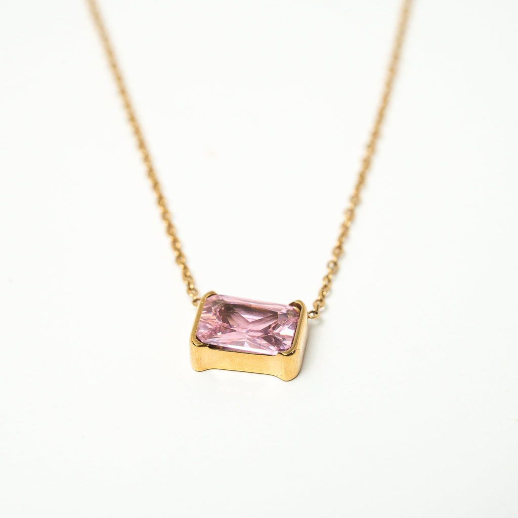 Gold necklace with a pink gemstone on a white background. Harma gold plated jewelry I Am Centered PINK Zirconia Necklace