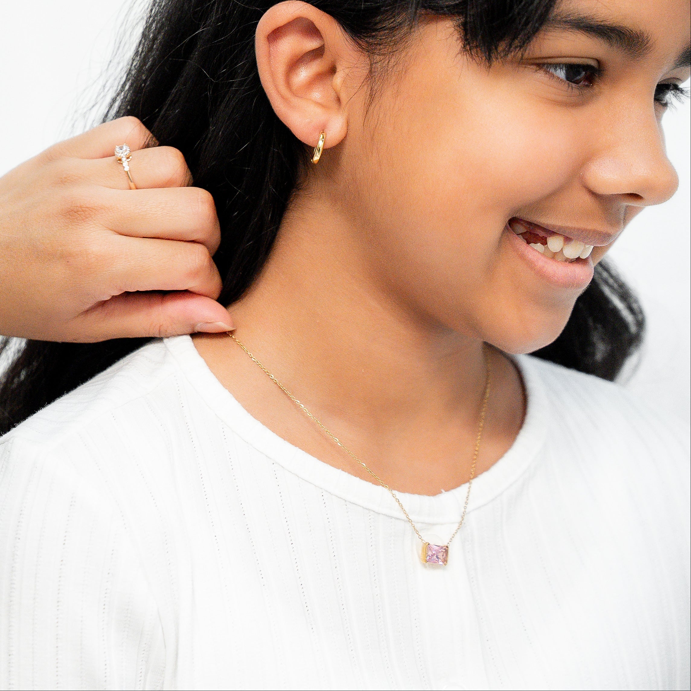 Woman adjusting a young girl's hair with a plain background. Harma gold plated jewelry I Am Centered PINK Zirconia Necklace