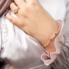 Close-up of a hand wearing a ring and bracelet on a light background. Harma jewelry gold plated I Am Loved Crystal Heart Bracelet