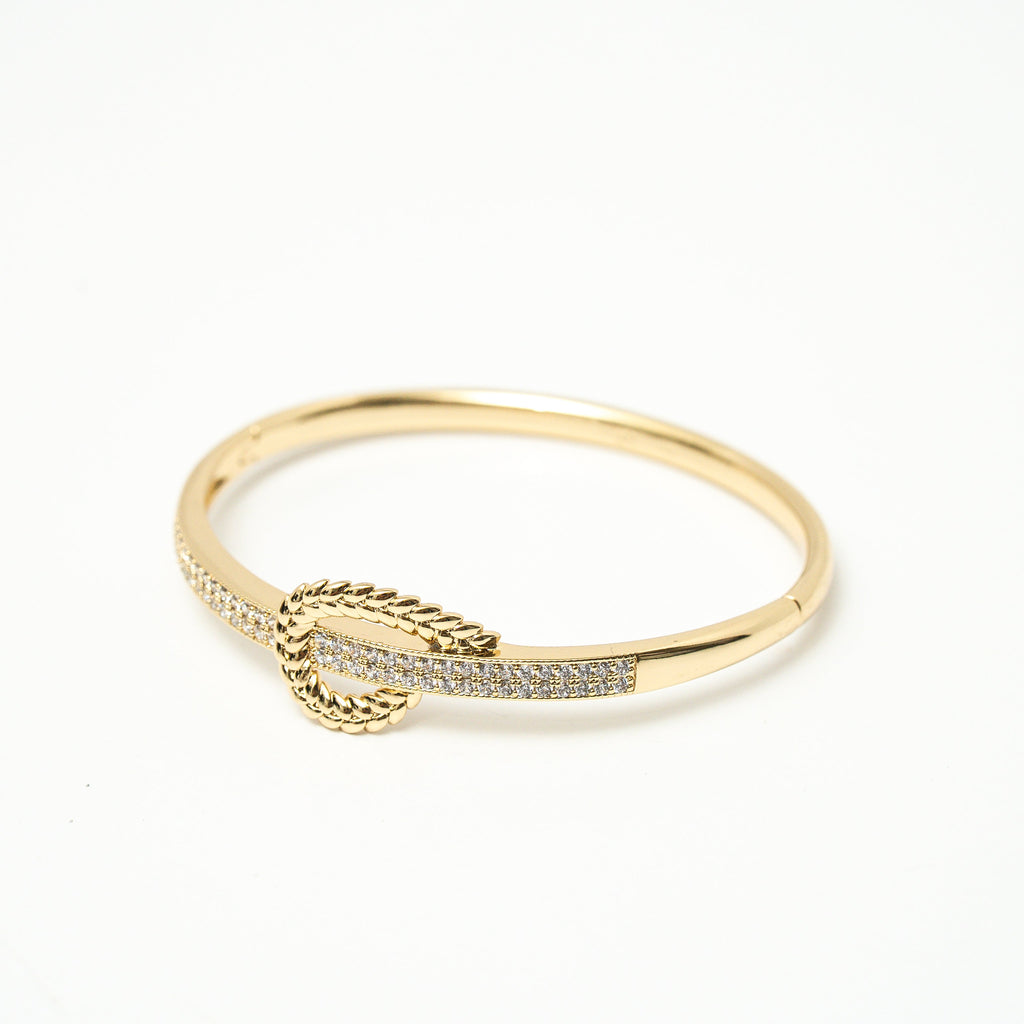 Gold bracelet with a decorative element on a white background. Harma jewelry gold plated I Am at Peace Vine Hoop Bangle Bracelet