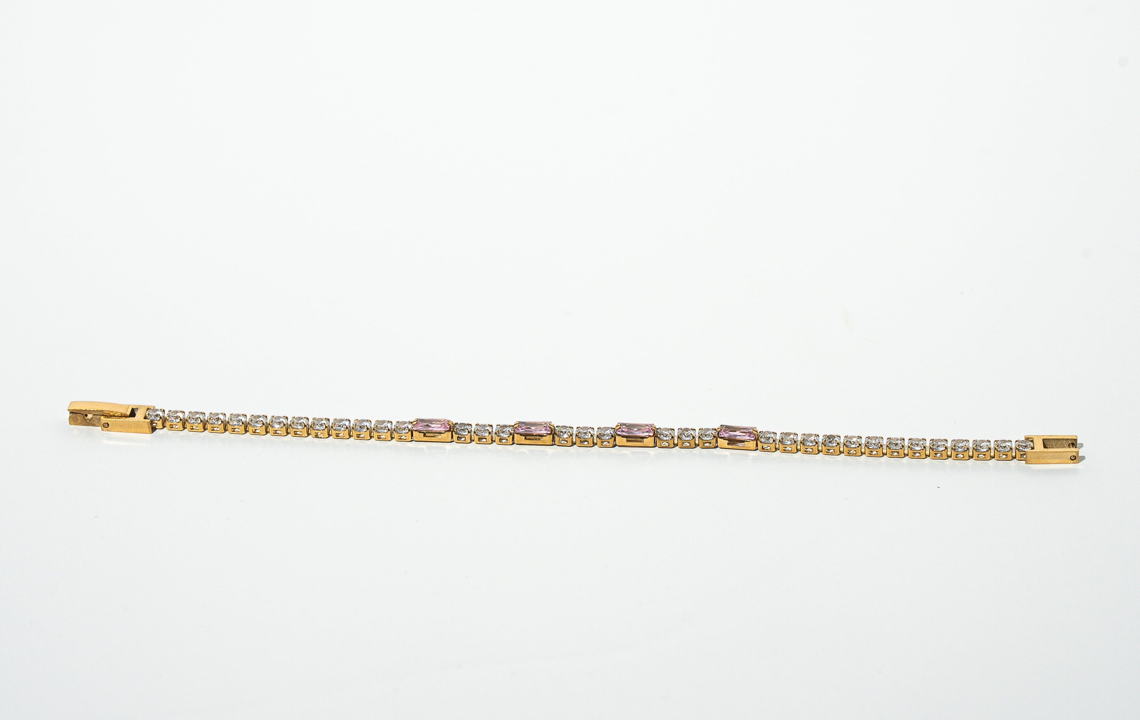 Gold bracelet with diamonds on a light gray background. Harma jewelry gold plated Moments of PINK Tennis Bracelet
