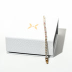 Bracelet displayed on a white box with a brand logo in the corner. Harma jewelry gold plated Moments of PINK Tennis Bracelet