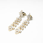 Harma jewelry gold plated chandelier earrings zircnoia hypoallergenic 14k. Gold earrings with clear stones on a beige card with a logo