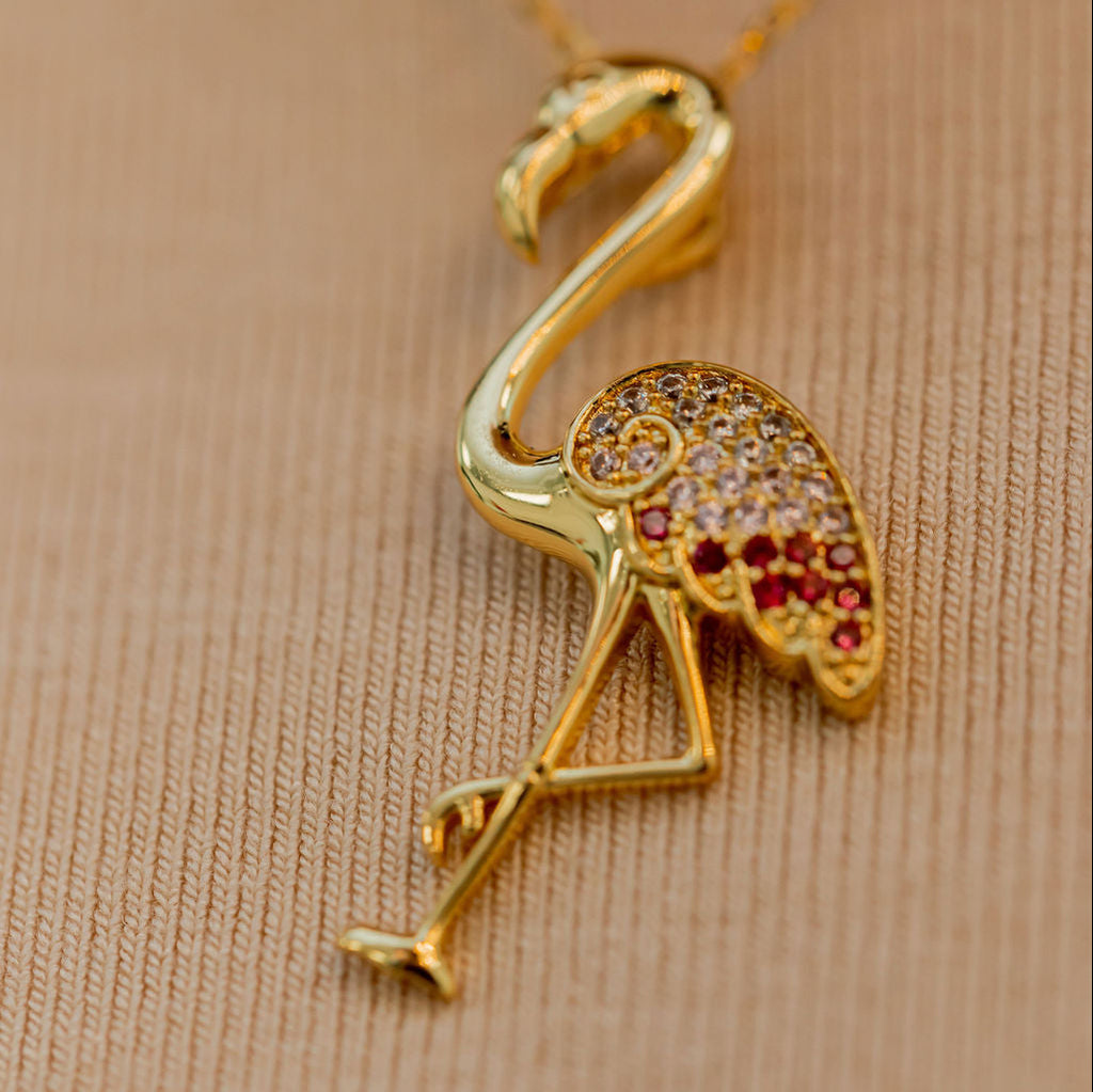 Gold flamingo pendant necklace on a beige background Harma jewelry s925 I Am Becoming PINK Again Flamingo Necklace 1