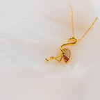 Gold flamingo-shaped pendant on a white background