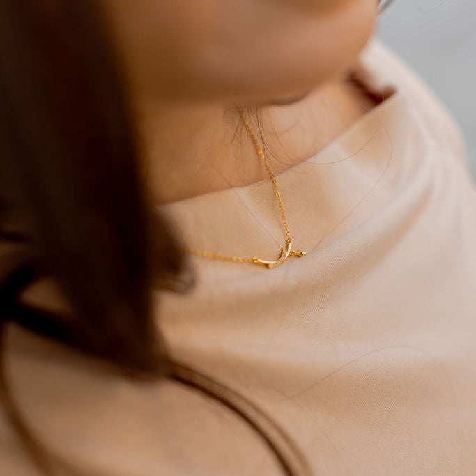 Close-up of a person wearing a gold necklace with a blurred background. Harma jewelry s925 I Am Guided Sparkle Sterling Silver Zirconia Necklace