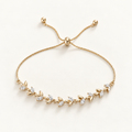 A delicate gold adjustable chain bracelet featuring a leafy vine design with small clear crystal accents, displayed on a clean off-white background. Whispering Magnolia Marquise Adjustable Bracelet 18k gold plated Harma Jewelry