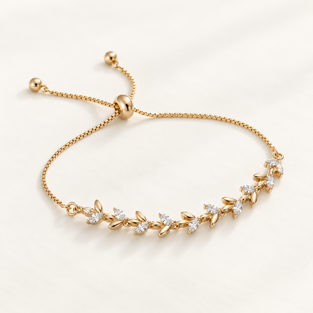 A delicate gold adjustable chain bracelet featuring a row of small leaf-shaped settings set with clear stones, displayed on a clean white background. Whispering Magnolia Marquise Adjustable Bracelet 18k gold plated Harma Jewelry
