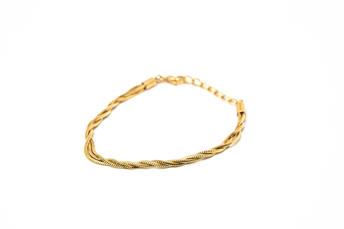 A gold-colored twisted rope chain bracelet with a lobster clasp, displayed on a clean white background. hARMA jewelry - I Am Evolving Twist 24K Bracelet